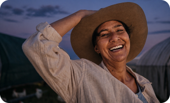 Woman smiling outdoors at golden hour